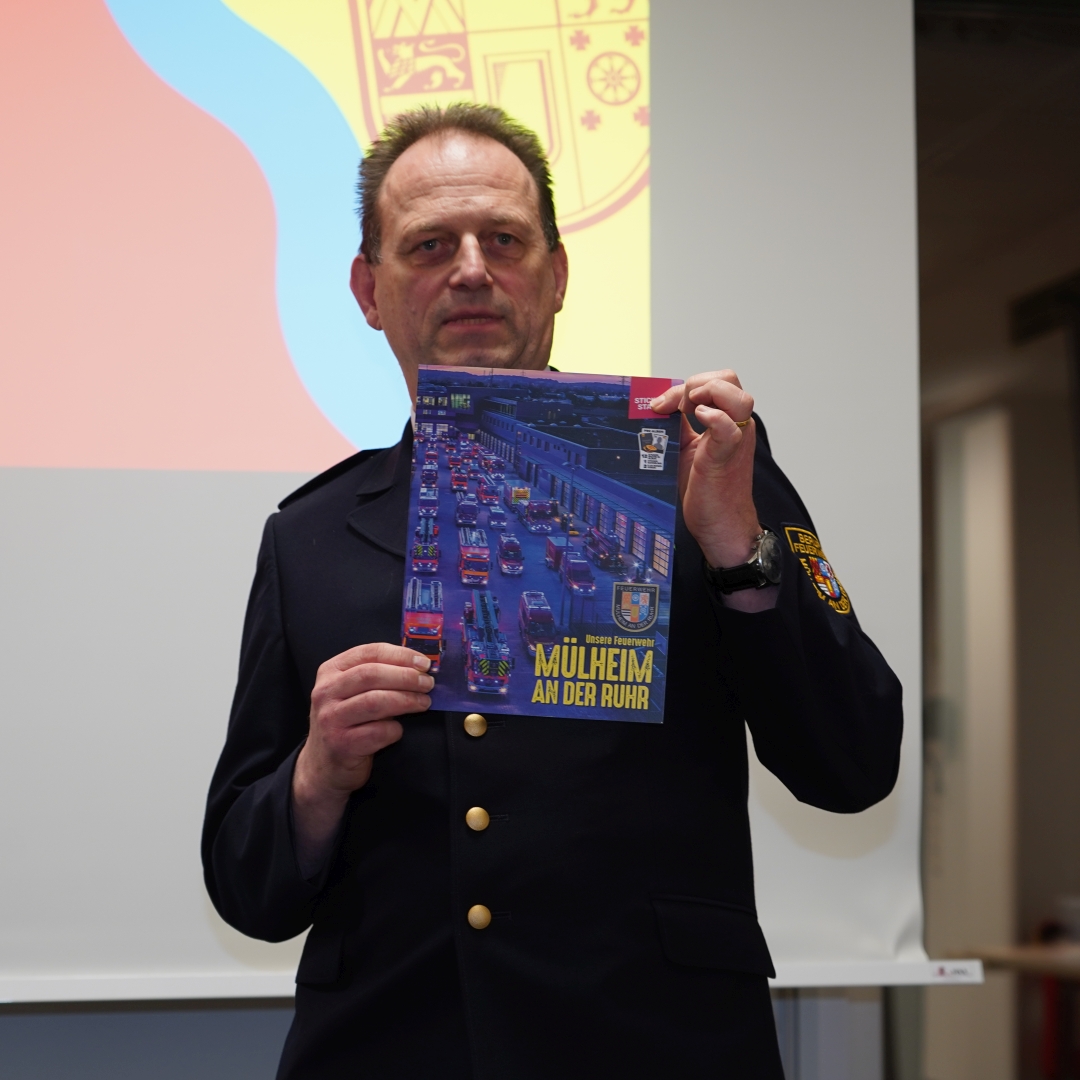 Der Leiter der Feuerwehr präsentiert das Stickeralbum